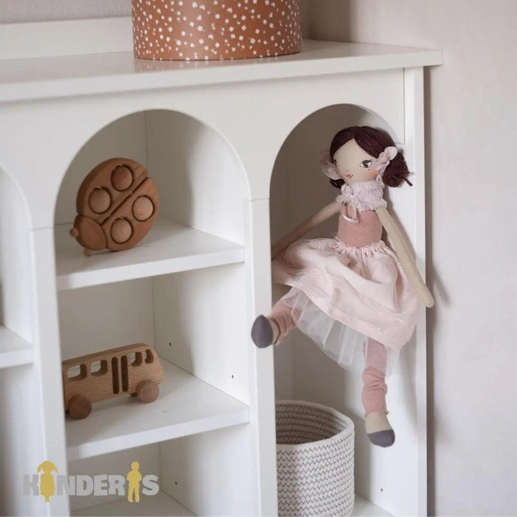 knygu ir zaislu lentyna su skirtingai stalcicais pastatyta vaiku kambaryje