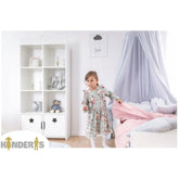 balta knygu ir zaislu lentyna pastatyta vaiko kambaryje