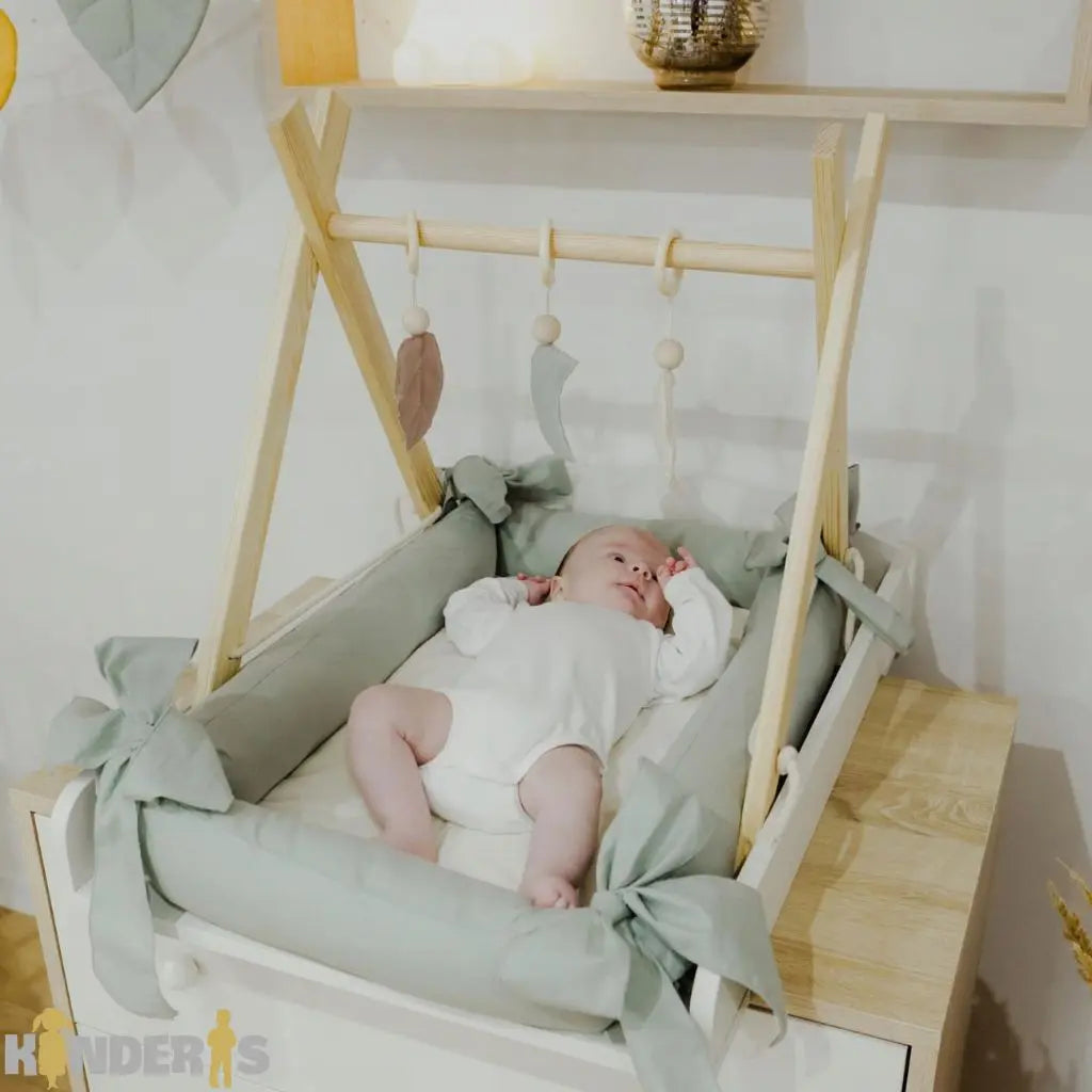 Medinis lavinamasis žaidimų stovas su pakabinamais žaislais vaiko kambaryje