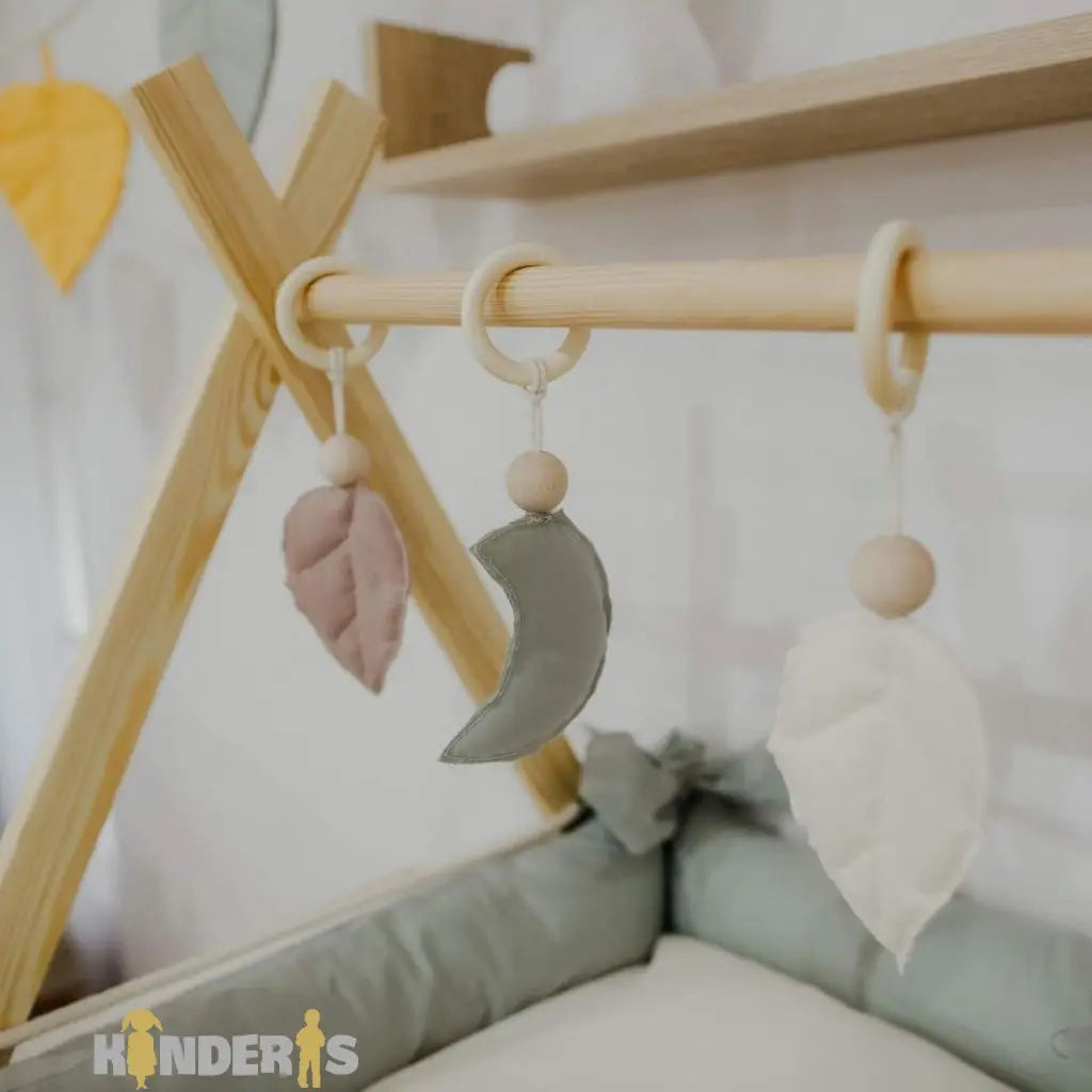Medinis lavinamasis žaidimų stovas su pakabinamais žaislais vaiko kambaryje