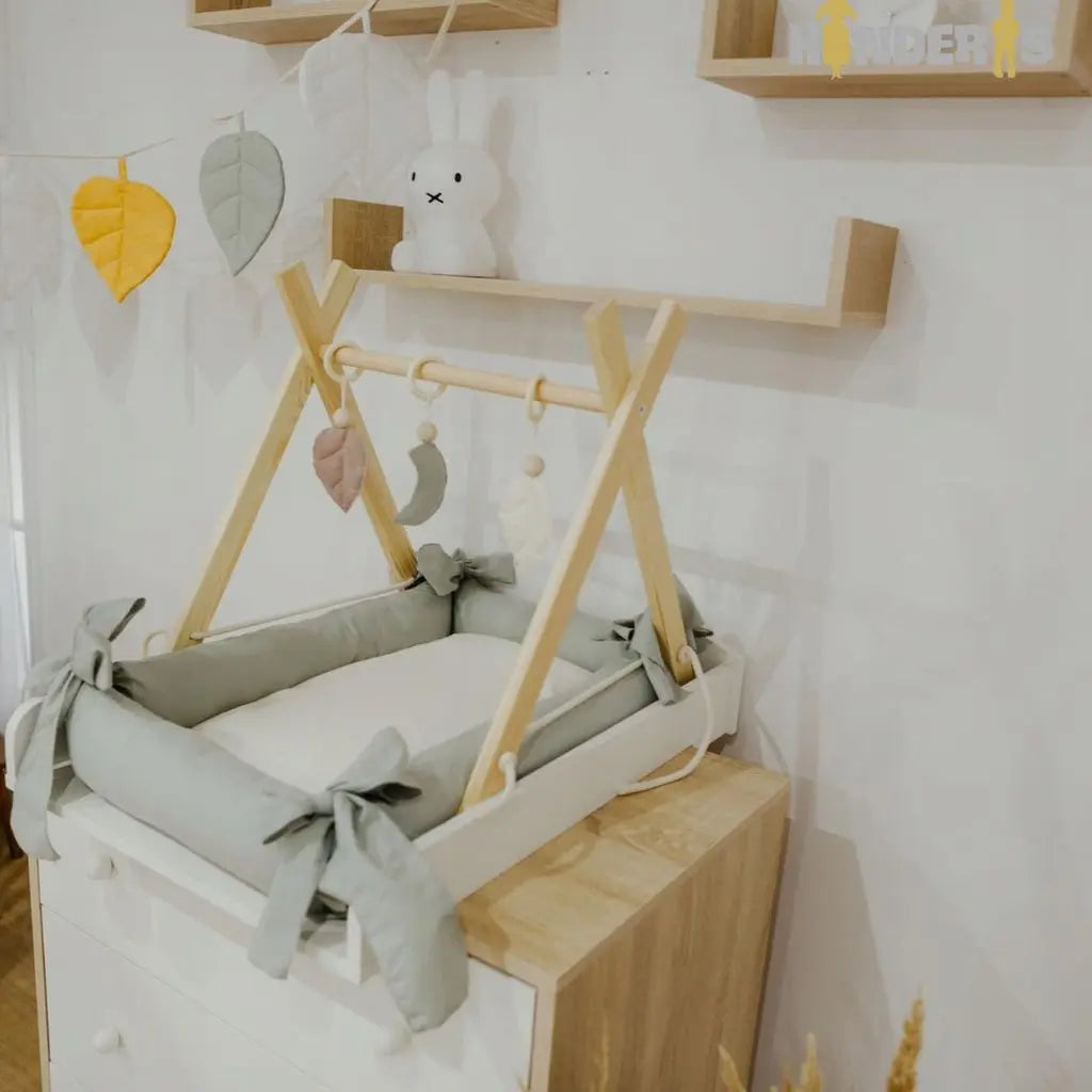 Medinis lavinamasis žaidimų stovas su pakabinamais žaislais vaiko kambaryje