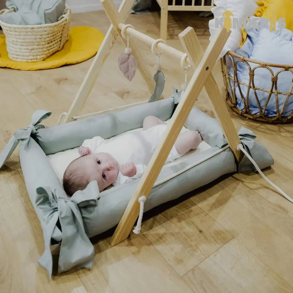 Medinis lavinamasis žaidimų stovas su pakabinamais žaislais vaiko kambaryje